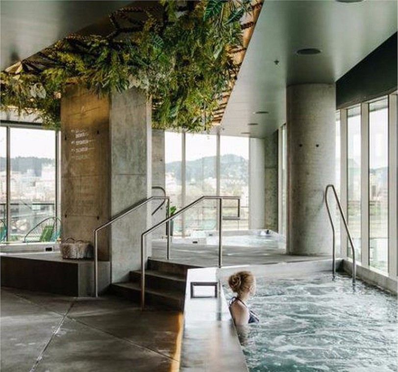 Indoor hydrotherapy pool with a living-plant ceiling and concrete columns